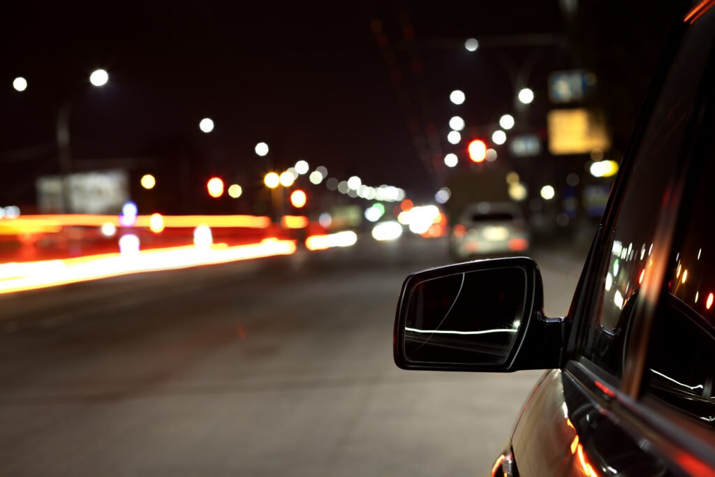 Carro mantendo uma distância segura de outro veículo como uma boa prática da direção noturna.